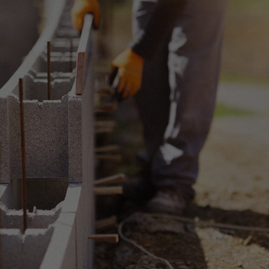 Professional masonry contractor laying concrete blocks for a new construction home in Bellevue, Washington.