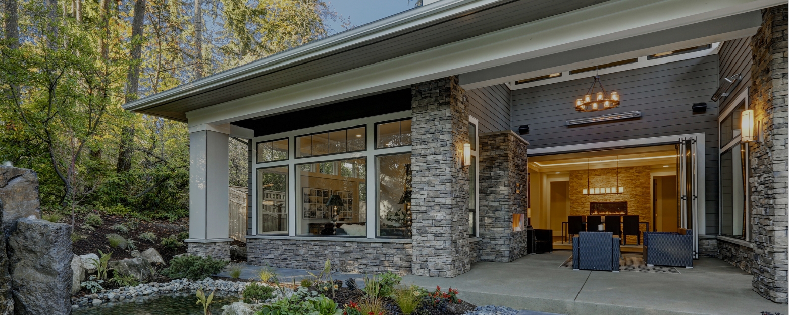 Luxury home in Sammamish, WA, featuring custom stone masonry columns, an outdoor living area, and a beautifully designed patio with stacked stone accents.