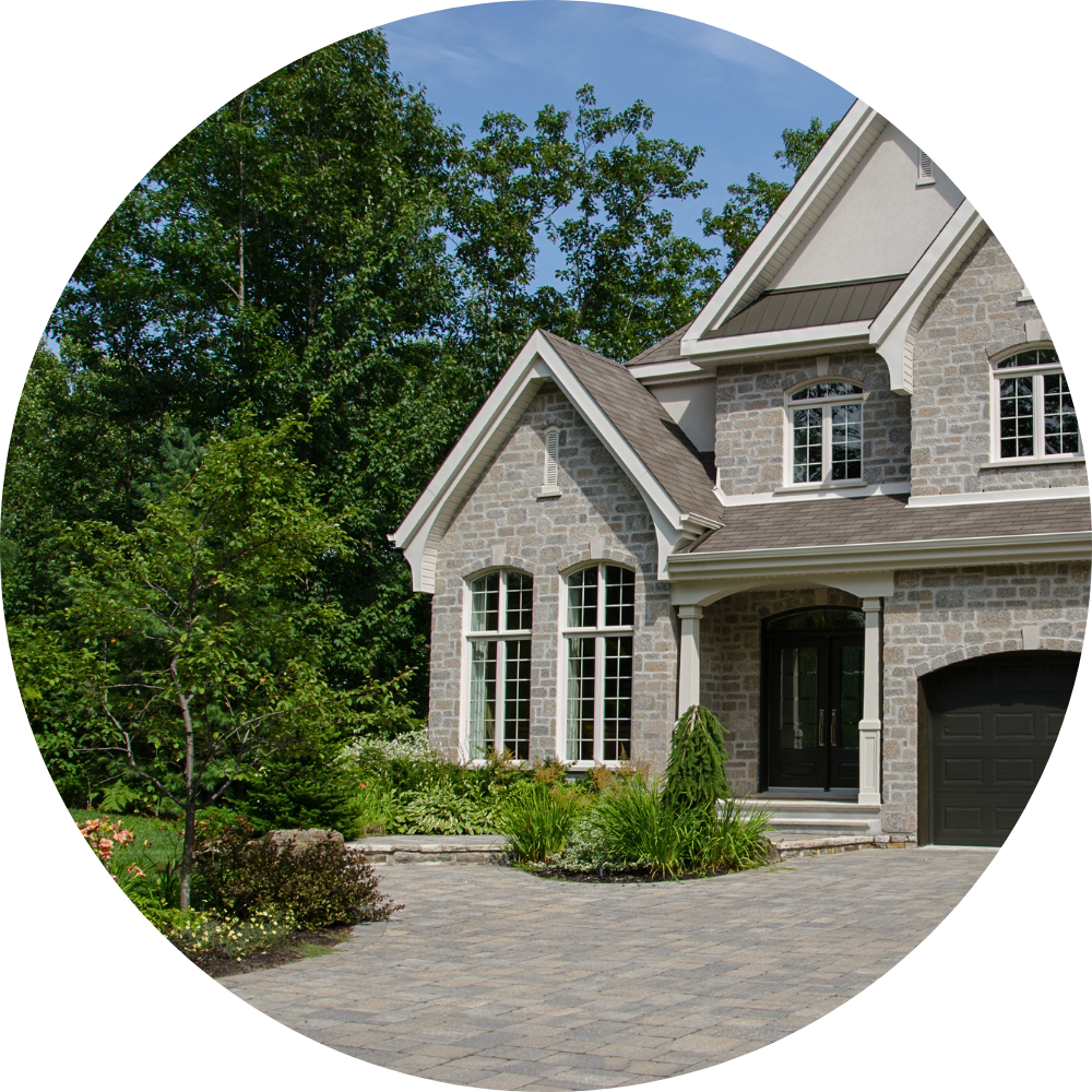 Classic Issaquah home surrounded by lush greenery, featuring high-quality stone masonry and a custom-built brick patio.